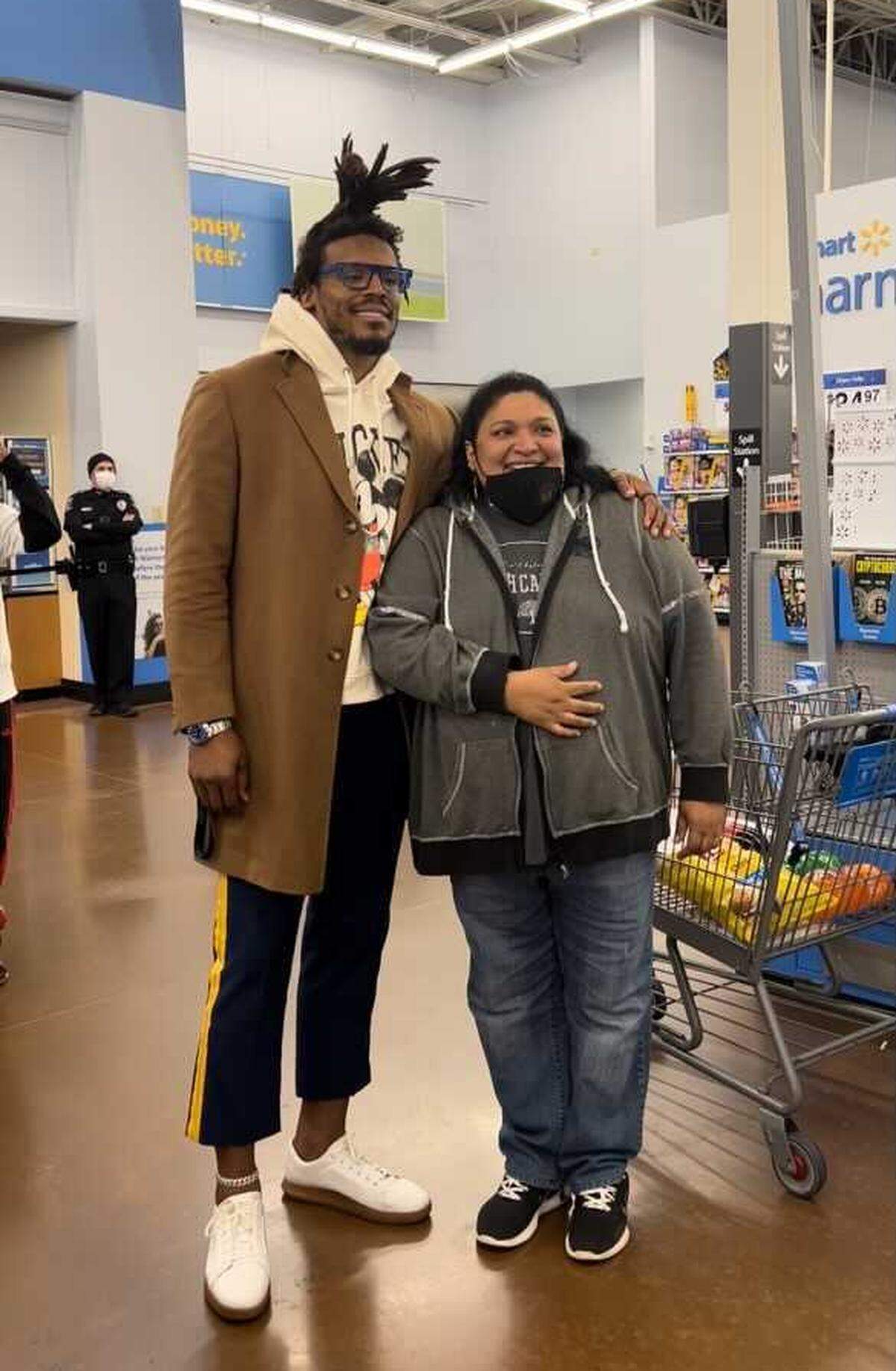 Carolina Panthers quarterback Cam Newton poses for a photo with a shopper at a Charlotte Walmart on Dec. 14, 2021.