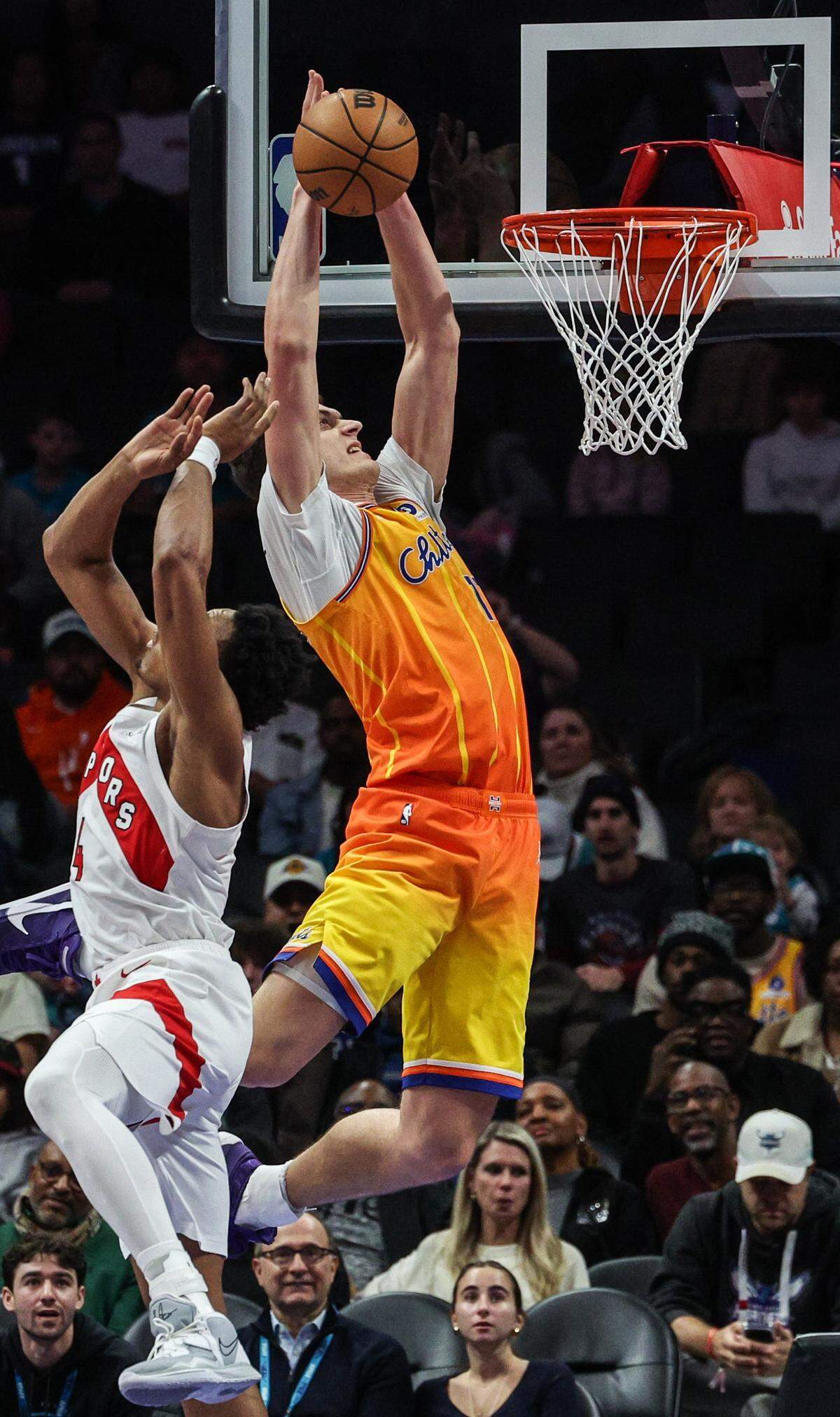Hornets center Ryan Kalkbrenner misses a dunk as Raptors forward Scottie Barnes gets in his path during the game at Spectrum Center in Charlotte, North Carolina, on Saturday, Nov. 29, 2025.