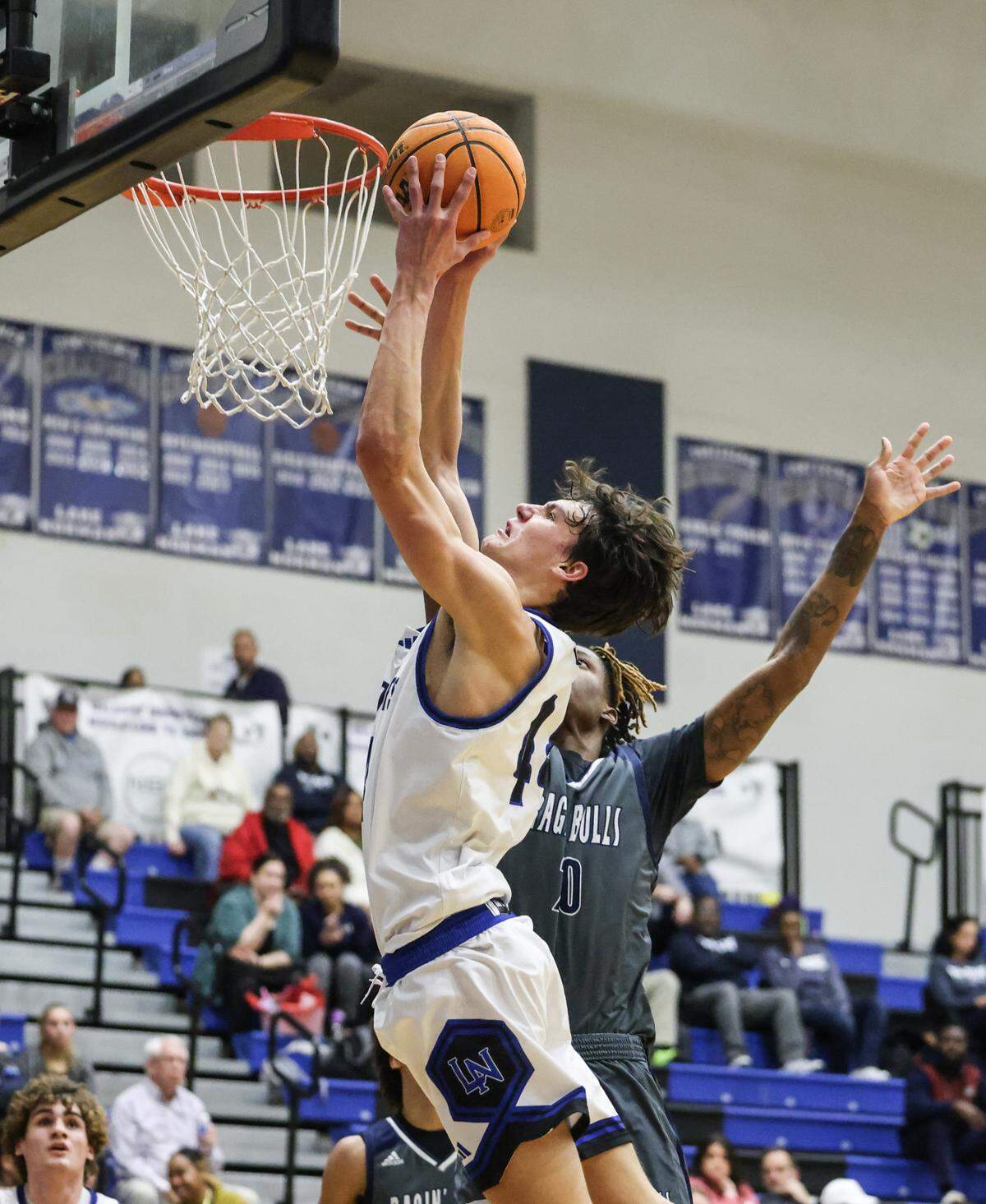 Lake Norman Wildcats Trent Steinour, front, shoots past a block by Hickory Ridge Ragin’ Bulls Wesley White at Lake Norman High School in Mooresville, N.C., on Tuesday, February 6, 2024.