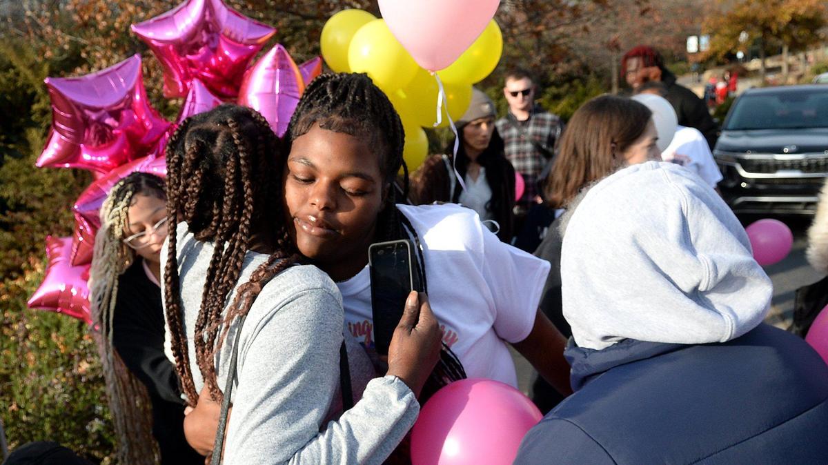 Karlotta Payton, 20, (center) hugs a well-wisher who was among about 20 friends and family of Ta’haley Payton who released yellow, pink and white balloons in Payton’s memory on a grassy knoll off Charlottetowne Avenue near uptown Charlotte on Saturday, Dec. 14, 2024.