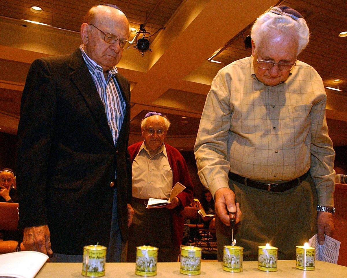 Irving Bienstock, at right, lights a candle in remembrance of the six million Jewish people killed during Holocaust. He is shown on April 18, 2004, at the annual Yom Hashoa, or Holocaust Remembrance Day observance at the Jewish Community Center in Charlotte.