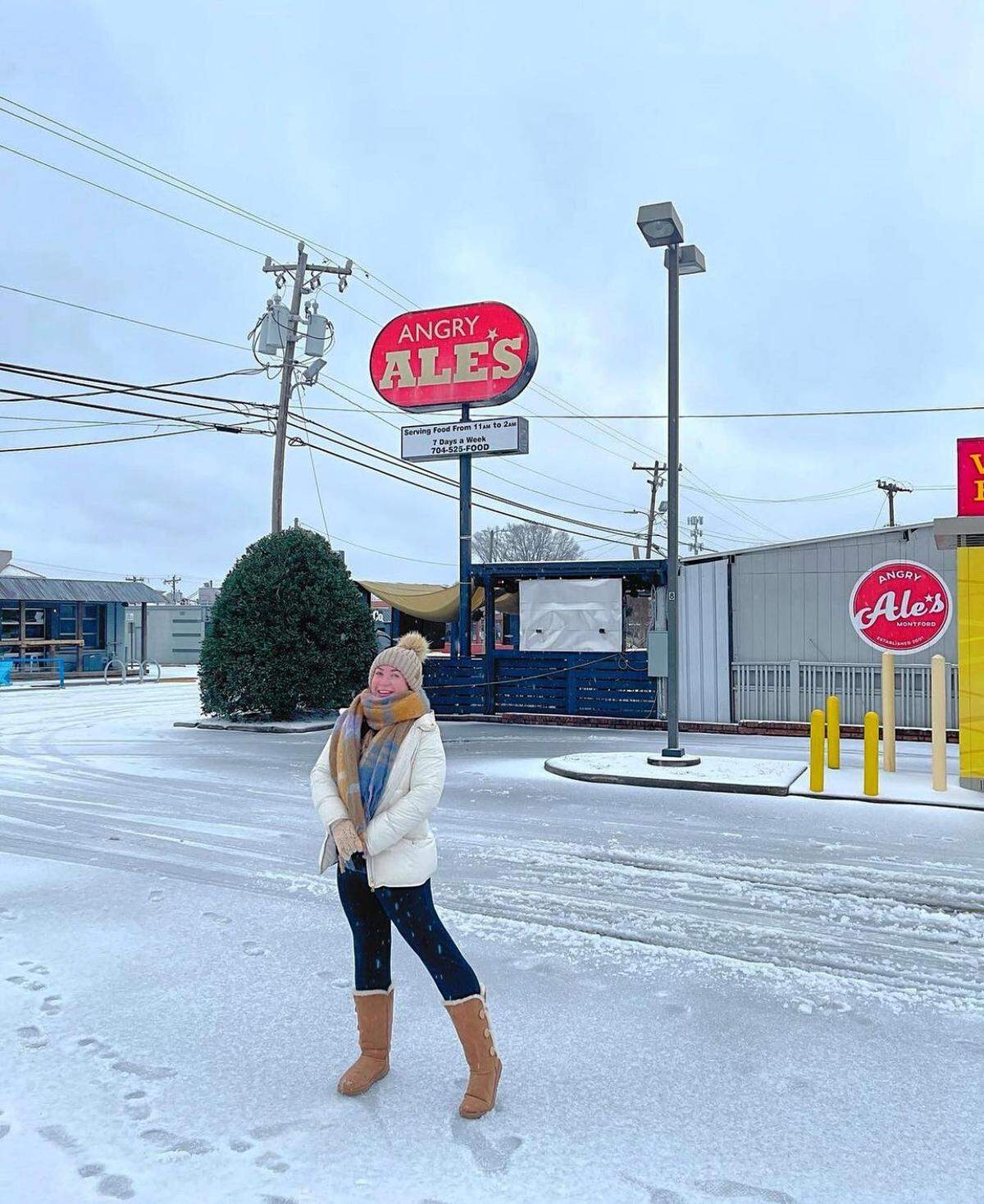An Angry Ale’s employee poses in front of the snowy bar on Montford Drive in January 2022.