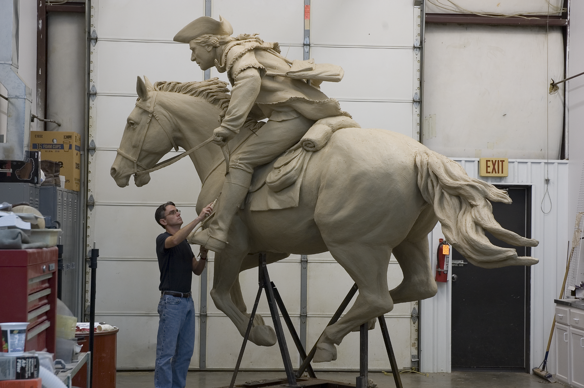 Charlotte sculptor Chas Fagan works on “The Spirit of Mecklenburg.” The bronze sculpture, which is 12.5 feet tall and 16 feet long, now sits uptown off Kings Drive along the Little Sugar Creek Greenway.