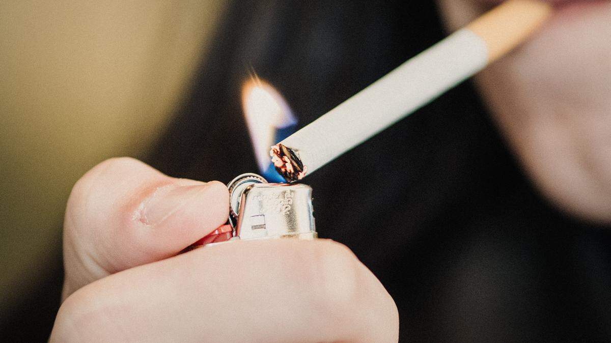 Photo illustration of a person lighting a cigarette with a lighter in Paris France on March 30, 2026. (Photo by Bastien Ohier / Hans Lucas / AFP via Getty Images)