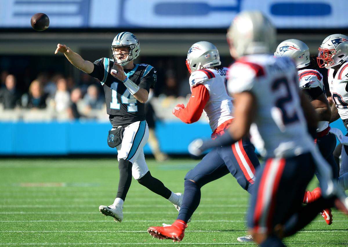 Carolina Panthers quarterback Sam Darnold is forced to scramble out of the pocket against New England in 2021 in a game the Patriots won, 24-6. The two teams will hold two joint practices this week in Massachusetts and then play each other in a preseason game Friday.