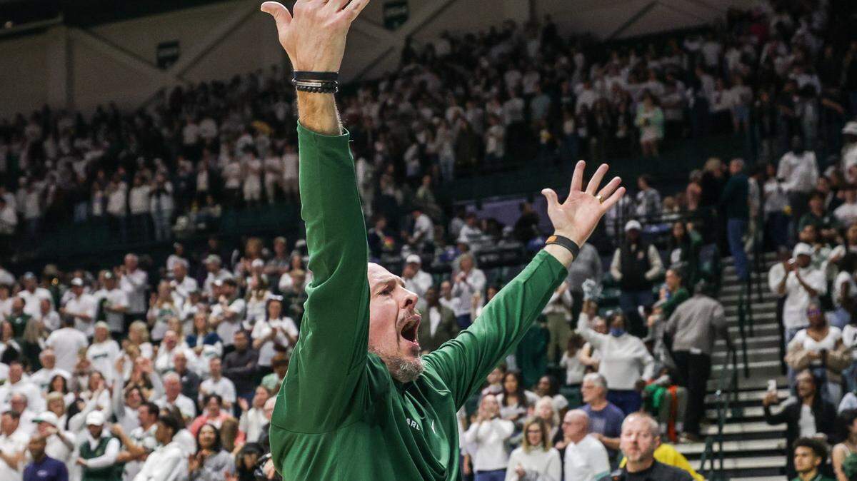 49ers Head Coach Aaron Fearne throws his arms up in celebration after a victory over the Pirates, 67-52, after the game at Halston Arena in Charlotte, NC, on Thursday, February 3, 2024. This win is the 49ers’ eighth consecutive win, a first in the team’s history.