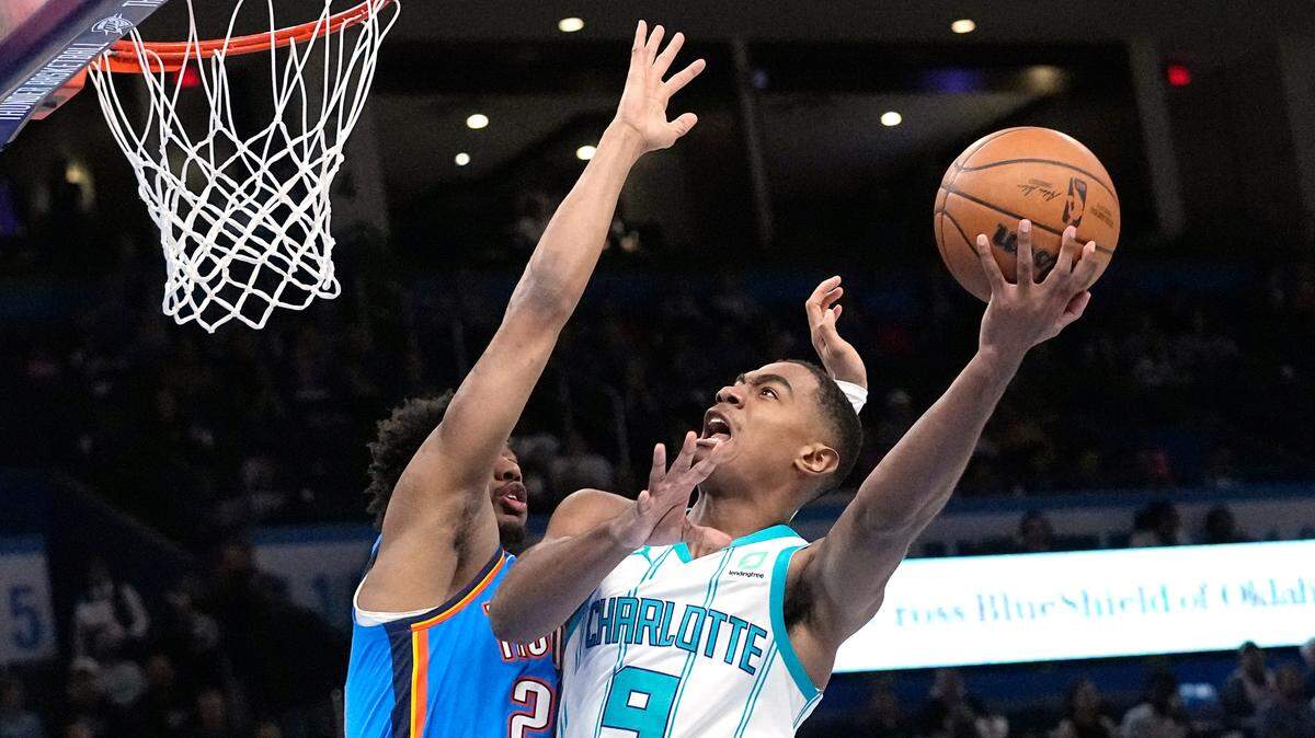 Charlotte Hornets guard Theo Maledon (9) shoots as Oklahoma City Thunder guard Aaron Wiggins, left, defends in the first half of Tuesday’s game in Oklahoma City. (AP Photo/Sue Ogrocki)