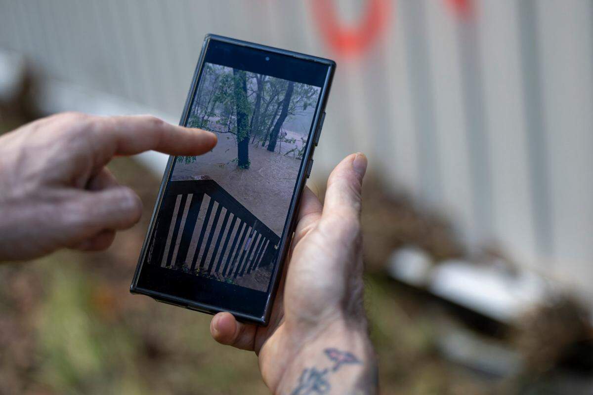 Daniel Mancini shows photos of the flooding from Hurricane Helene that destroyed his home along the banks of the Broad River on Sunday, October 6, 2024 in rural Buncombe County, near Black Mountain, N.C.