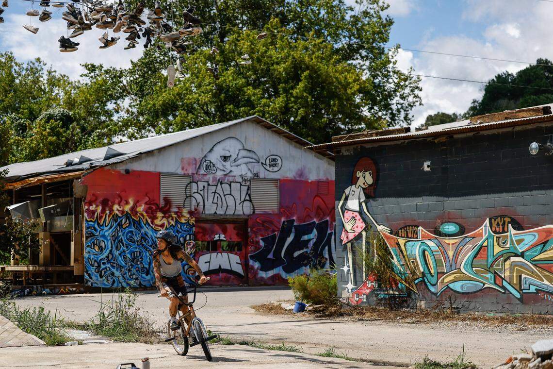 A woman, who asked not to be identified, rides in the skate park in the River Arts District in Asheville. While debris still litters areas of the skate park, the ramps are mostly cleared and open for riding. Meanwhile the buildings surrounding the park sit in ruin, completely destroyed by flooding last year during Helene.