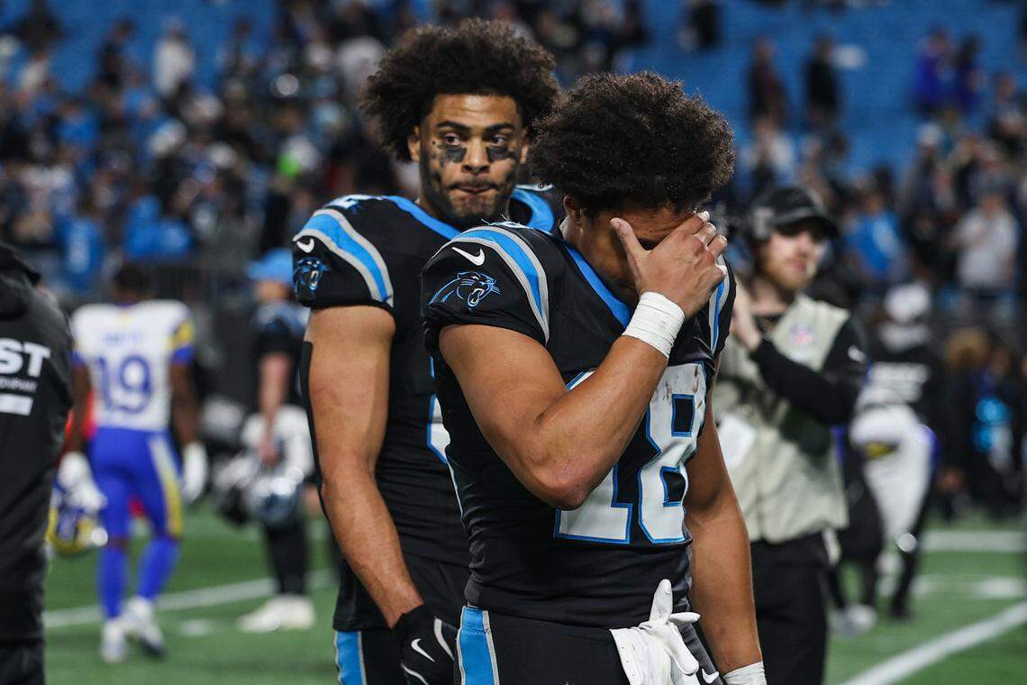 Panthers wide receiver Jalen Coker, front, puts his head in his hand as he walks off the field after a loss to the Rams in the Wild Card playoff game, 34-31, at Bank of America Stadium in Charlotte on Saturday, Jan. 10, 2026.