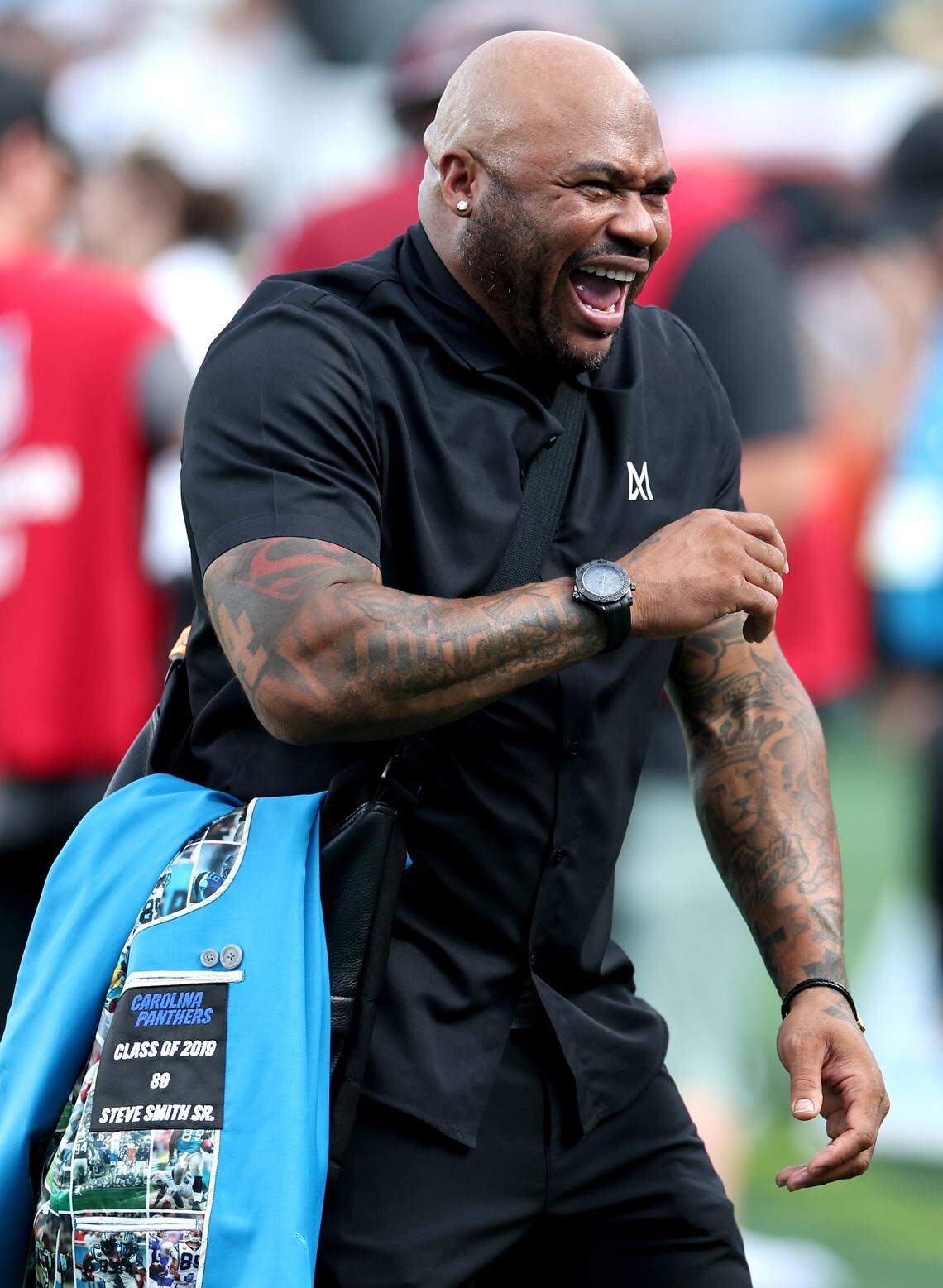 Former Carolina Panthers wide receiver Steve Smith enjoys a laugh with former teammates along the sideline at Bank of America Stadium in Charlotte, NC on Thursday, August 21, 2025. The Panthers hosted the Pittsburgh Steelers in their final preseason game of the new season.