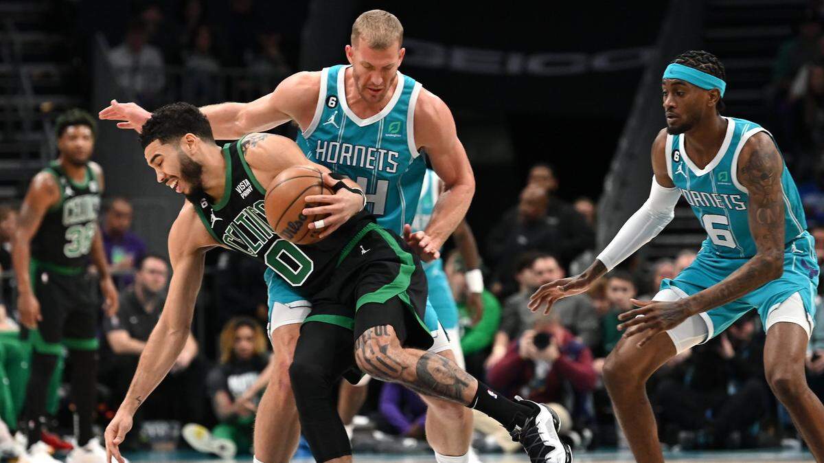 Boston Celtics forward Jayson Tatum, left, fights to get around Charlotte Hornets center Mason Plumlee, center and forward Jalen McDaniels, right, during first half action at Spectrum Center in Charlotte, NC on Monday, January 16, 2023.