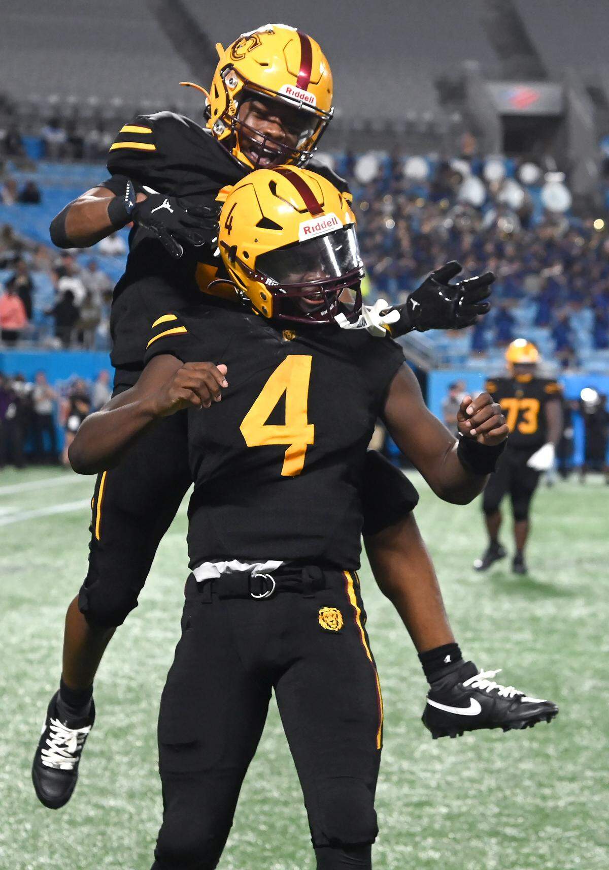West Charlotte Lions quarterback Jamouri Nichols is congratulated by a teammate after rushing for a touchdown during overtime against the Grimsley Whirlies. The teams were competing in the Keep Pounding Classic at Bank of America Stadium on Friday, Aug. 22, 2025. Grimsley defeated West Charlotte 28-27.