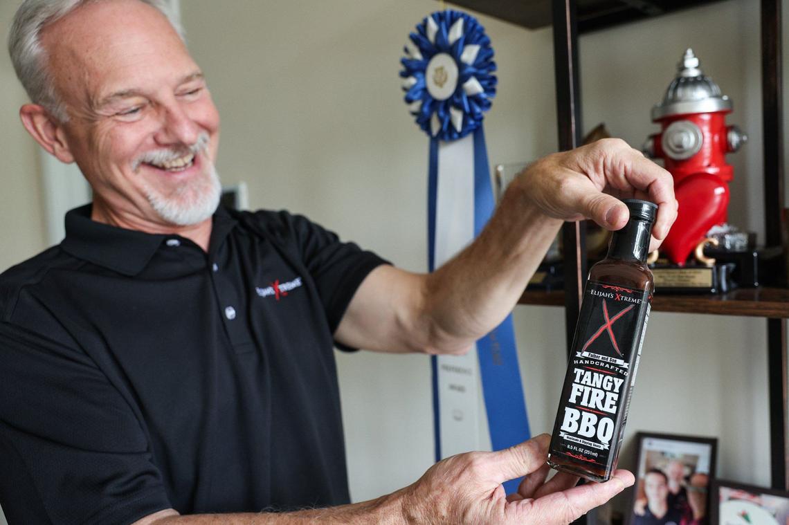 Bret Morey shows off one of the company’s marinades and barbecue sauces, which has won 64 awards.