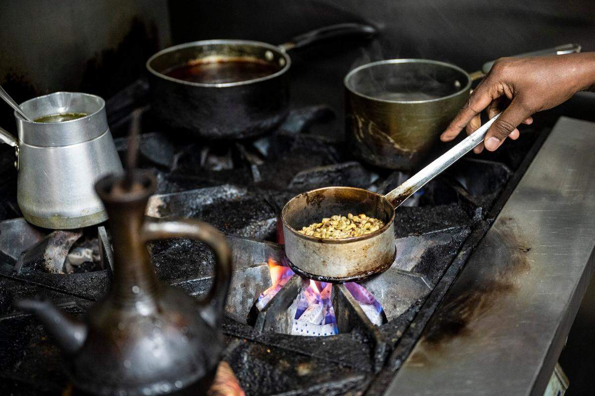 Shito Negussie roasts coffee beans over the flames as she prepares traditional Ethiopian coffee for herself and daughter before they open their restaurant, Abugida.