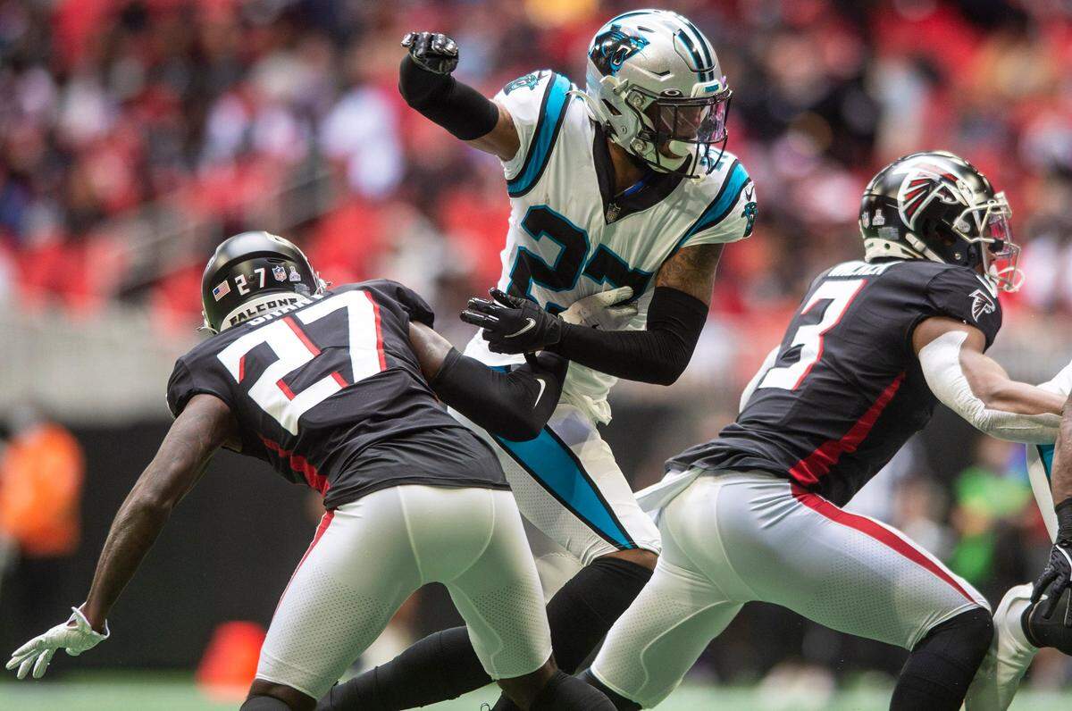 Panthers safety Kenny Robinson, center, escapes the grasp of Falcons safety Richie Grant, left, during the game against the Falcons at Mercedes-Benz Stadium on Sunday, October 31, 2021 in Atlanta, GA.