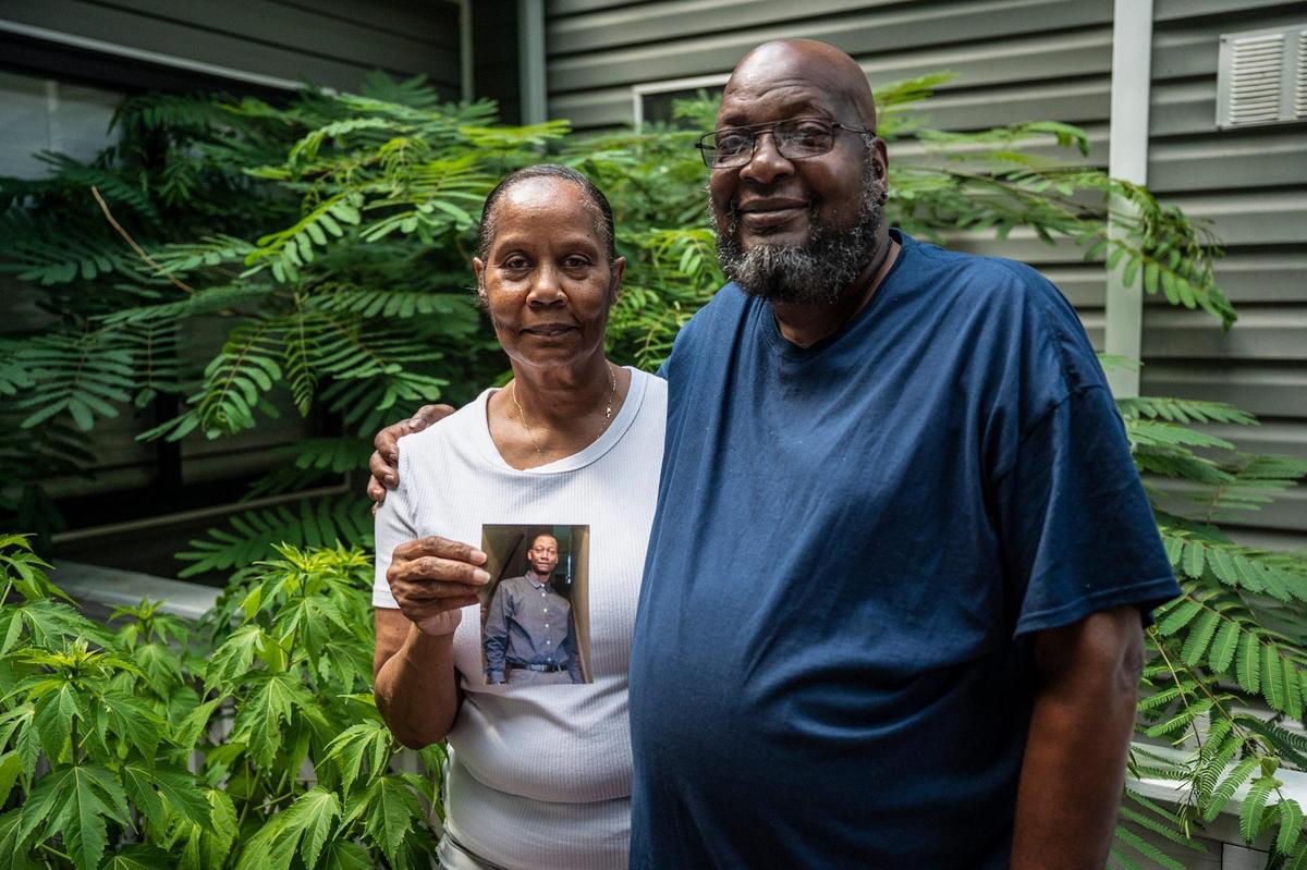 Bridgette Billings, left, and her husband Charles, with a photo of their late son, Jamaa Cassell, at their home on May 31, 2022 in Charlotte. Two years ago, Cassell was one of four people killed at a Juneteenth celebration on Beatties Ford Road. To this day, the case remains open and no suspects have been charged.