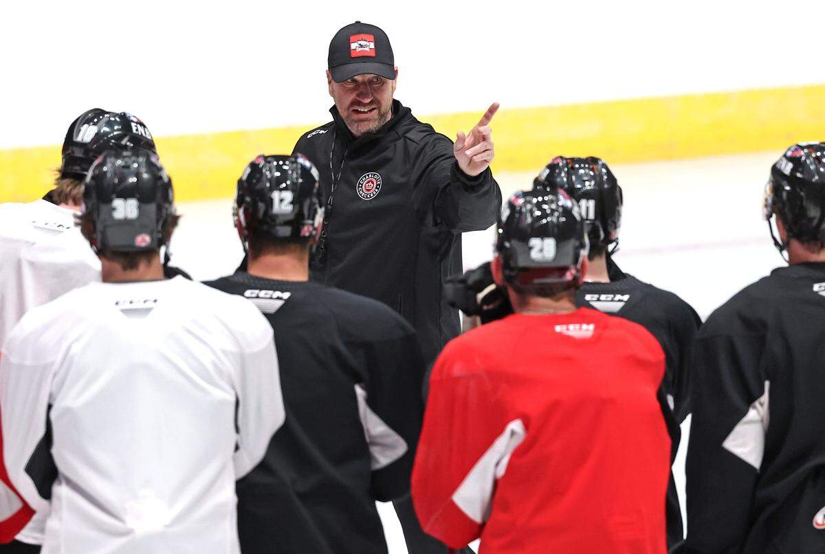 Charlotte Checkers head coach Geordie Kinnear, center, speaks to his team during practice at BoJangles Coliseum in Charlotte, NC on Thursday, October 9, 2025.