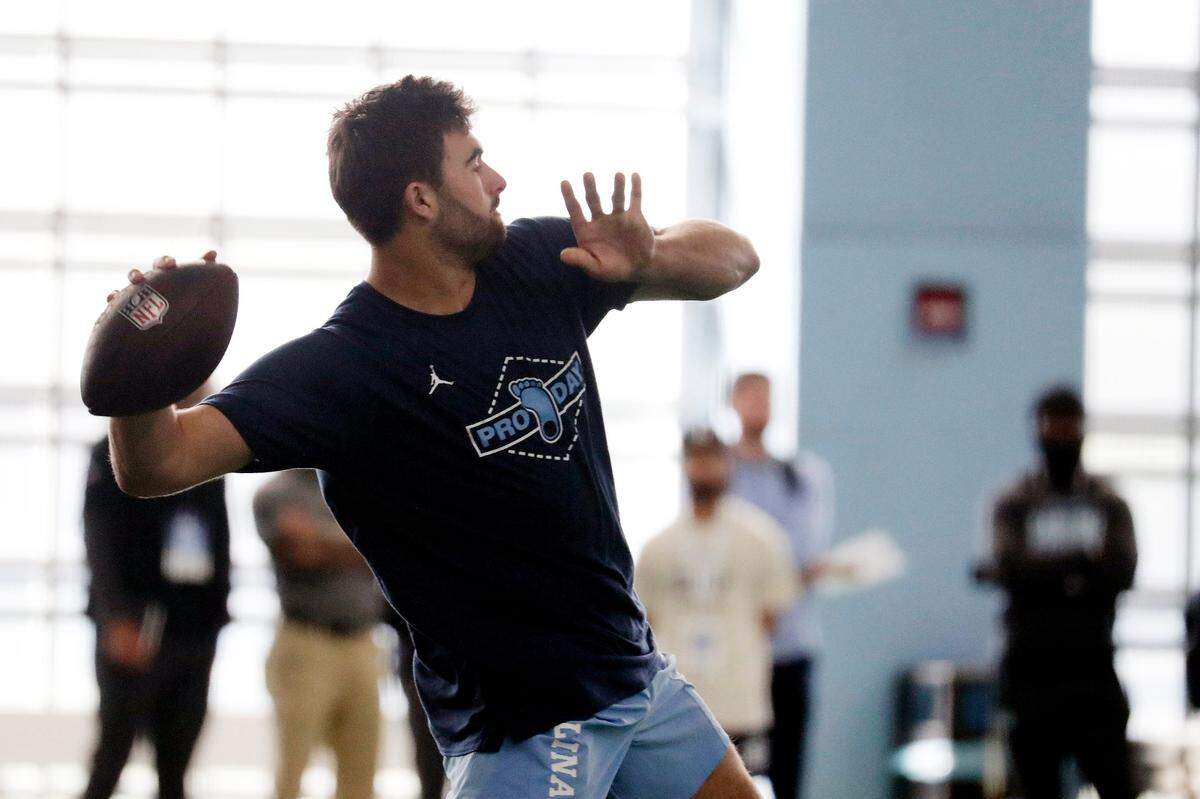 North Carolina quarterback Sam Howell demonstates his skills as NFL scouts look on during Pro Day, Monday, March 28, 2022, in Chapel Hill, N.C. (AP Photo/Chris Seward)