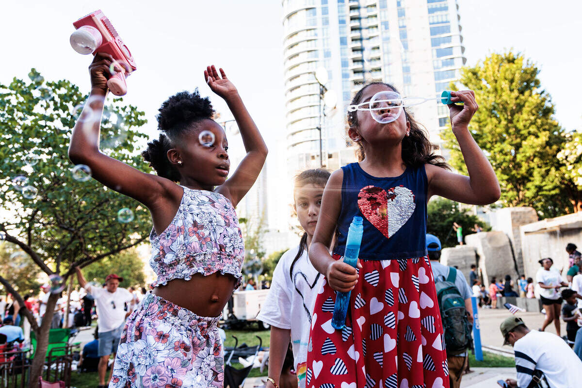 Six-year-olds Elysia King (left) and Eve Marquez have a “bubble party” at Romare Bearden Park on Saturday July 4, 2026.