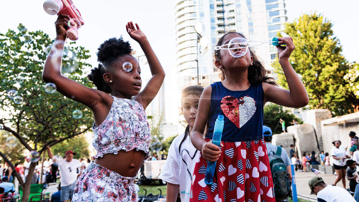 Six-year-olds Elysia King (left) and Eve Marquez have a “bubble party” at Romare Bearden Park on Saturday July 4, 2026.