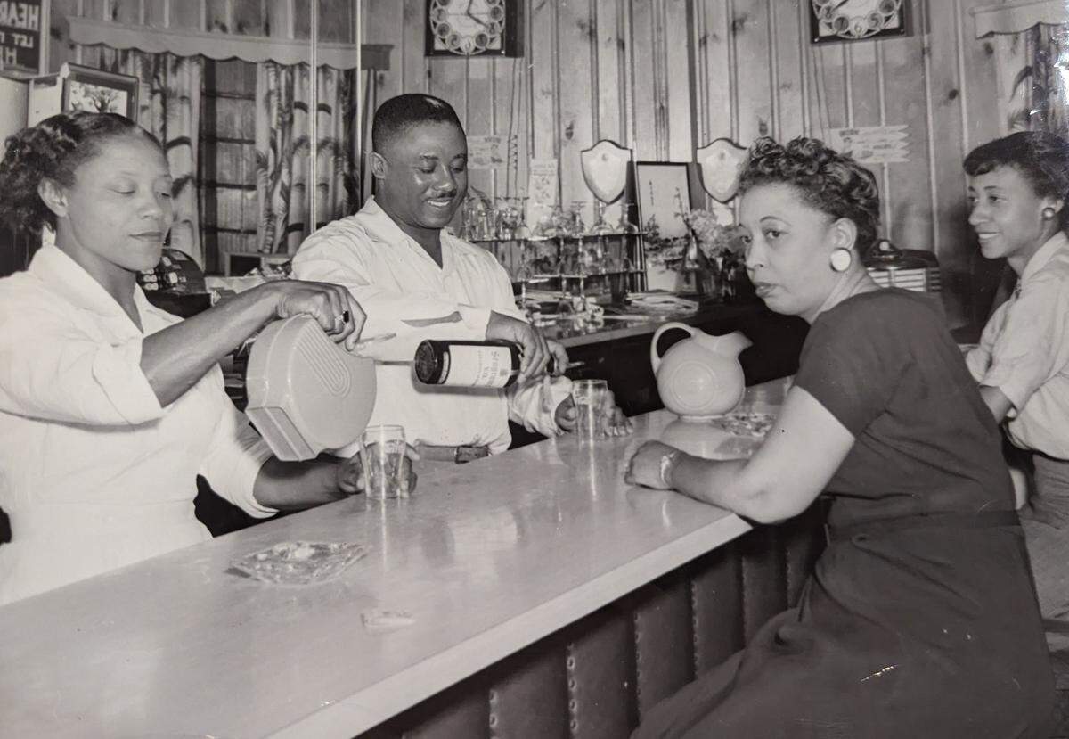 James McKee pours a drink for customers at the bar of the Excelsior Club in Charlotte.