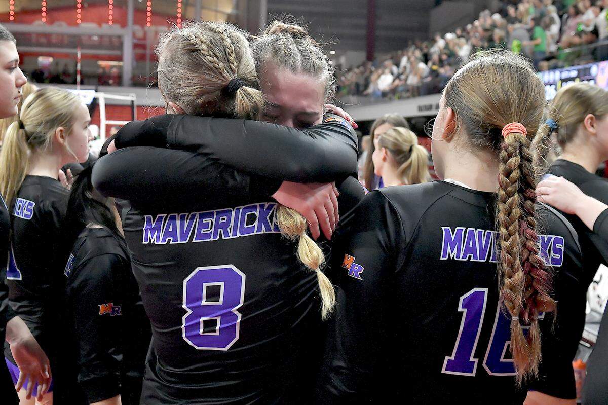 Marvin Ridge’s Ashley Murray (8) and Kiley Petras (7) embrace, and with Lauren Davis (16) react to their loss to Cardinal Gibbons in the NCHSAA 4A Volleyball Championship game.