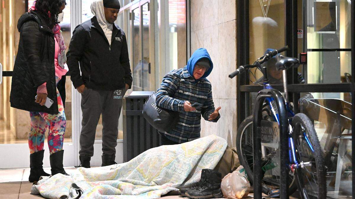 Point-in-Time Count volunteers Jeanelle Perry, left, and Jerald Collins, center, listen while volunteer Joe Hamby, right, speaks with a person who is homeless along Church St. in uptown Charlotte, NC., on Jan. 26, 2023. Volunteers aim to get an accurate statistic of how many people in Charlotte are homeless, live in shelters or tents or cars, or otherwise have unstable housing arrangements.