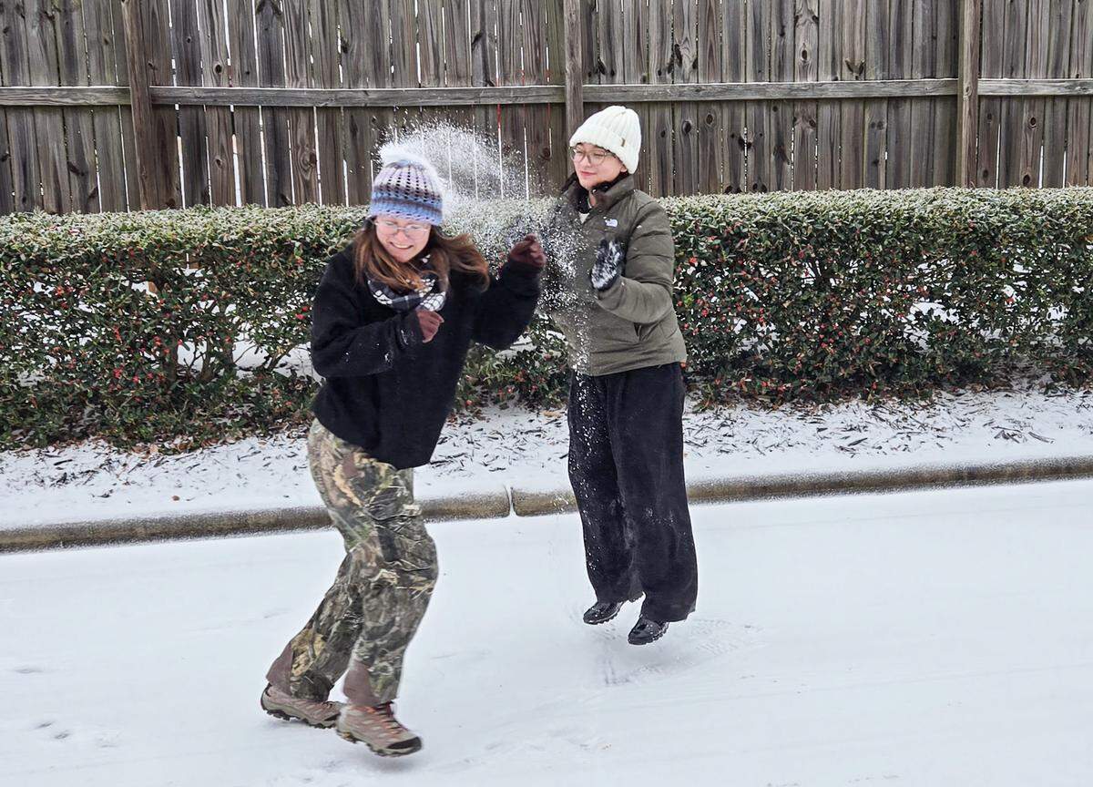 Heidi Baumgartner, center, is on the receiving end oa snowball from D'ascia Muir as they enjoy the snow in the University area of Charlotte on Sunday, January 25, 2026.