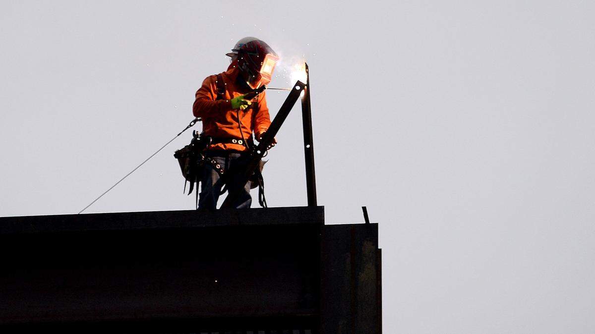 A construction worker welds atop the Charlotte Convention Center in May 2020. Hispanic workers make up a large percentage of construction employees across the state. They also work in key industries like manufacturing, agriculture, restaurants and personal care services, which all face labor shortages.