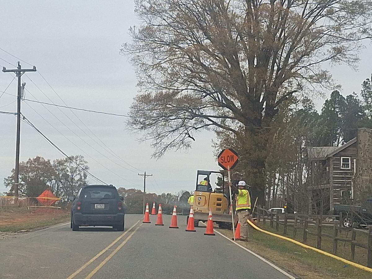 Construction workers on Rinehardt Road in Mooresville held “Stop” and “Slow” signs to let large construction trucks into and out of the massive Cambrey Pointe site on Thursday. Loud drills replaced the typical quiet along the former country road.