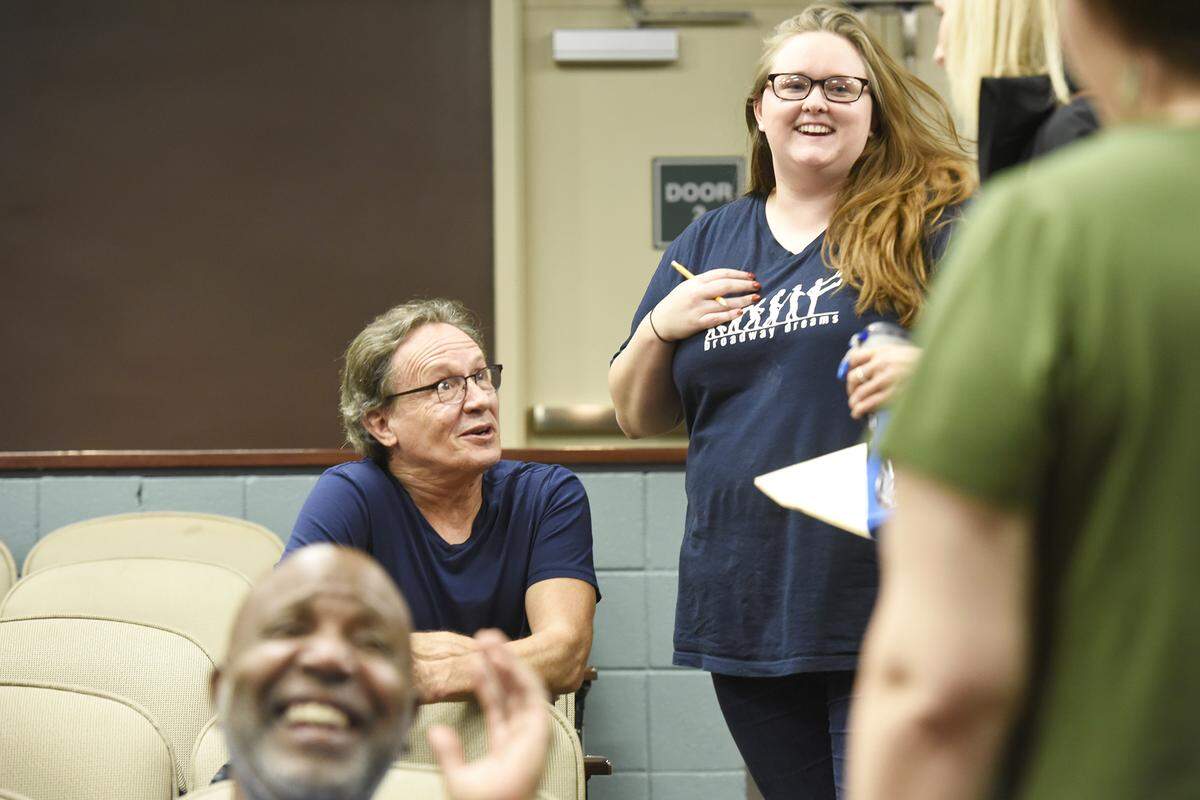 Ron Chisholm, director and choreographer, jokes with Payton Dills and cast members prior to rehearsal at Pease Auditorium.