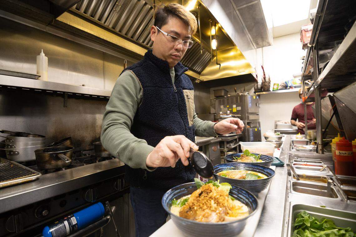 YUME owner and chef Patrick Tong finishes ramen dishes in the kitchen.