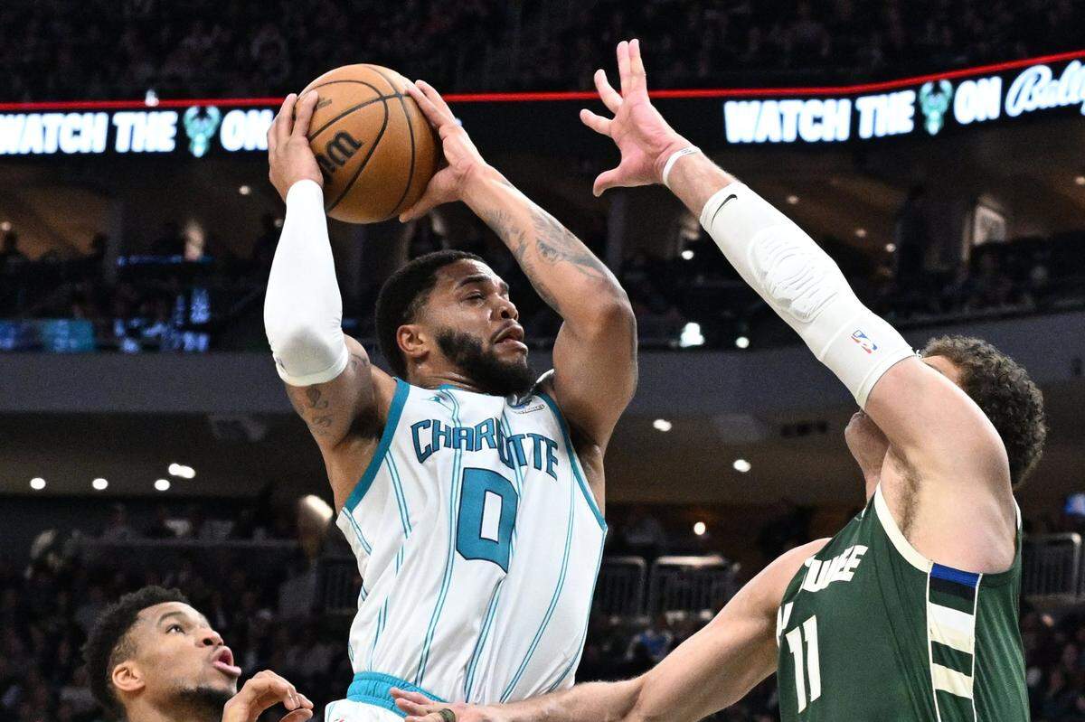Charlotte Hornets forward Miles Bridges (0) drives to the basket against Milwaukee Bucks center Brook Lopez (11) in the first half at Fiserv Forum.