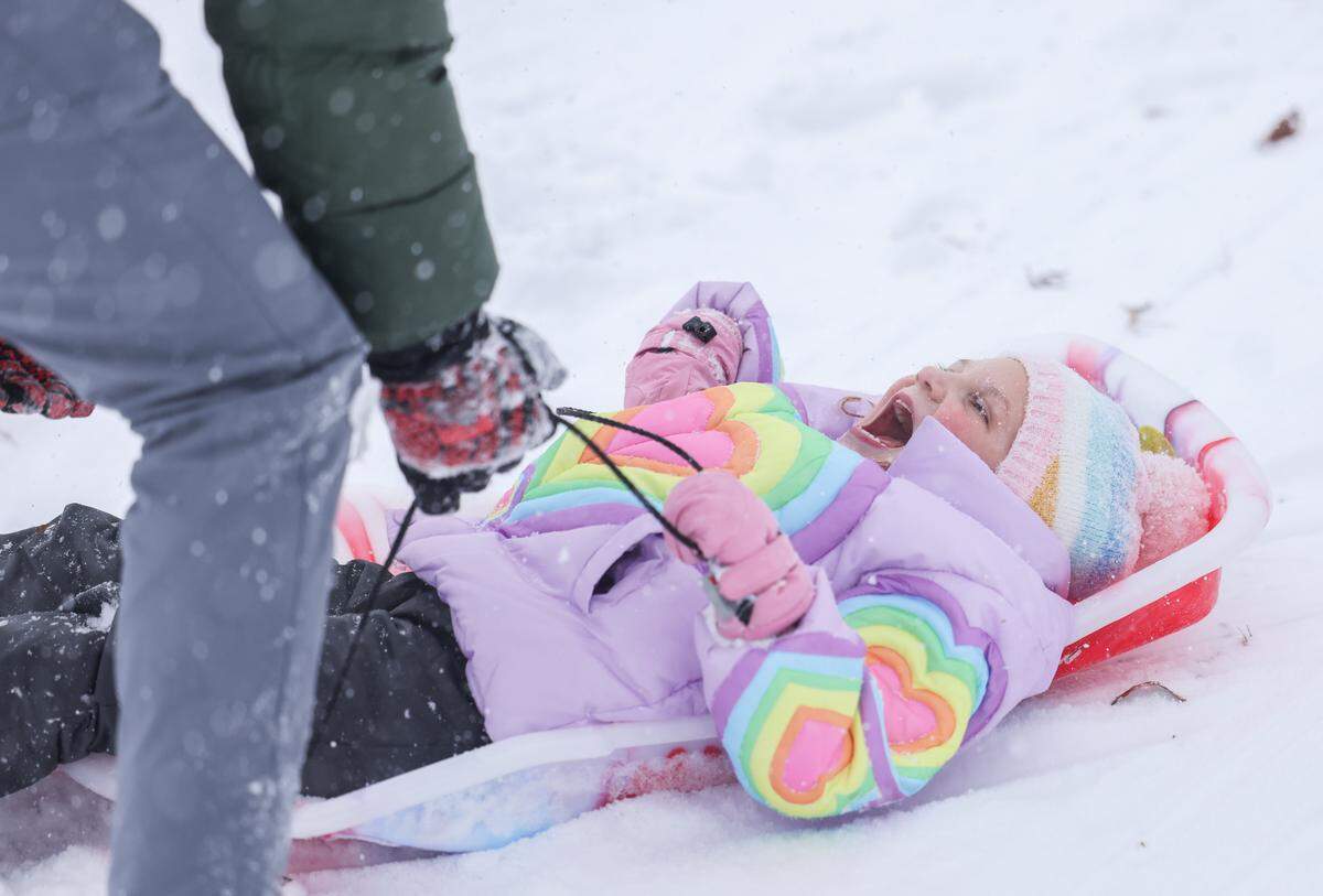 A little girl laughs in the snow in Cordelia Park in Charlotte, N.C., on Saturday, January 31, 2026.