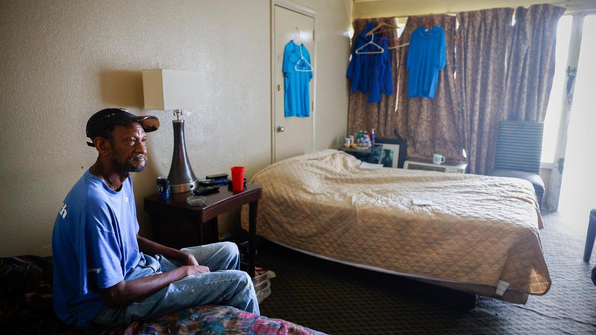 Leroy McKinney watches television in his room at the Southern Comfort Inn in Charlotte, Thursday, June 2, 2022. McKinney shares a room in with his sister and will be forced move at the end of the month when the motel closes.