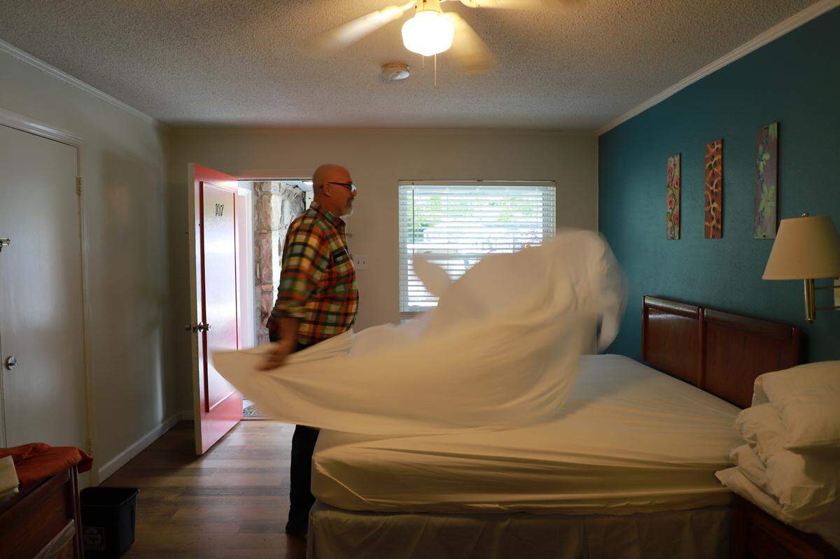 Joseph Franklyn McElroy makes a bed inside a room at the Meadowlark.
