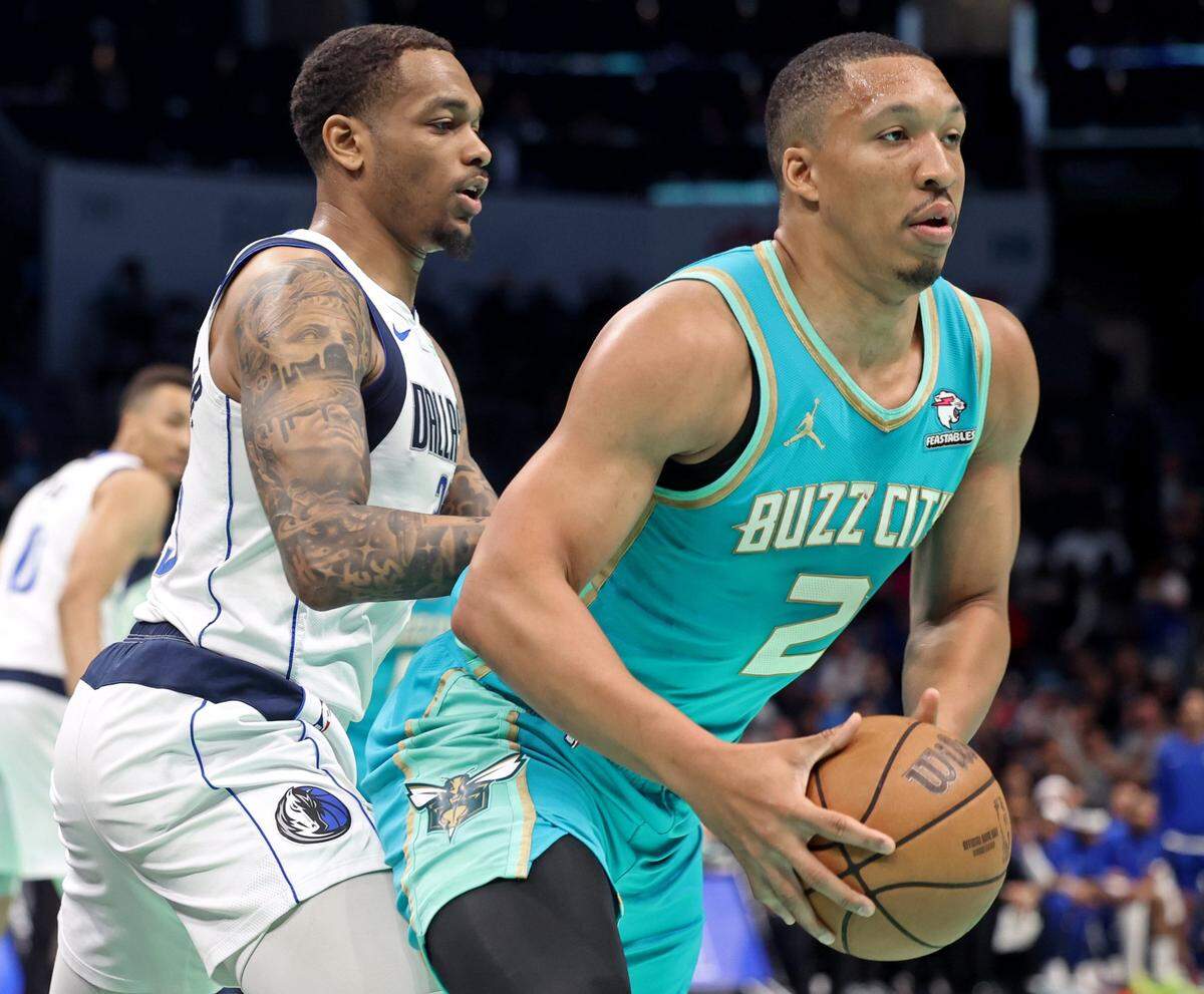 Dallas Mavericks forward P.J. Washington, left, applies defensive pressure on Charlotte Hornets forward Grant Williams, right, during first-half action on Tuesday, April 9, 2024 at Spectrum Center in Charlotte, NC.