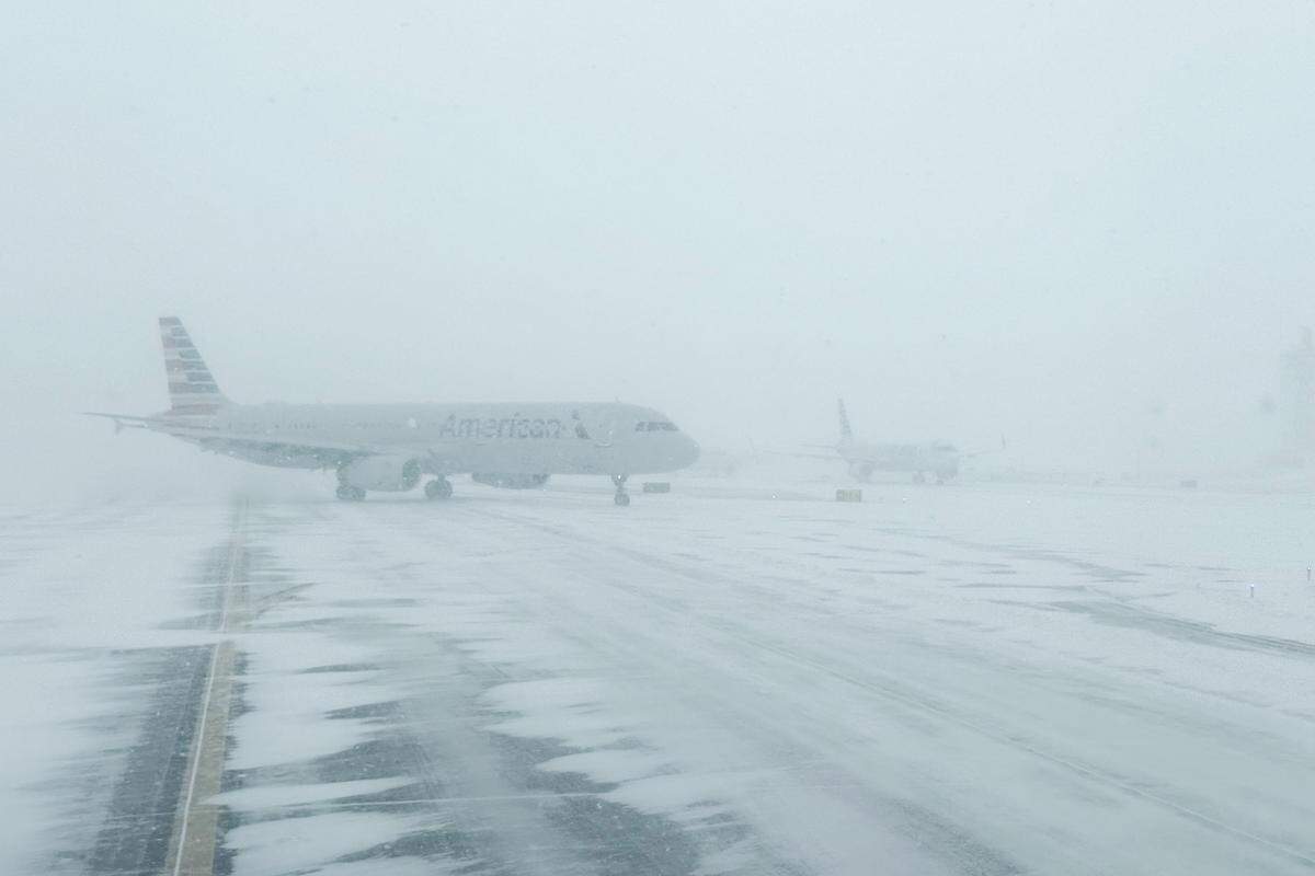 An American Airlines plane moves across a snow-covered tarmac at Charlotte Douglass Airport on Saturday, Jan. 31, 2026. The  airport experienced hundreds of flight delays and cancellations Saturday due to the snowstorm.