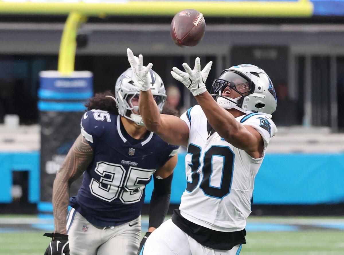 Carolina’s Chuba Hubbard reaches for the ball Sunday as the Panthers and Cowboys play in Charlotte.