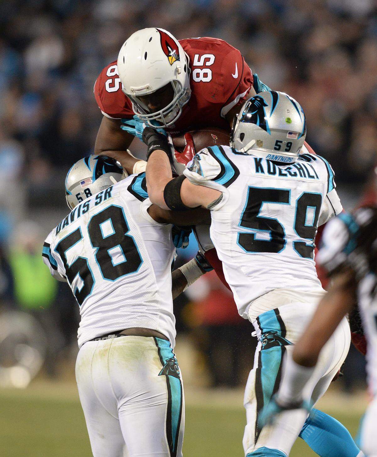 Cardinals tight end Darren Fells is stopped by Panthers defenders Thomas Davis (58) and Luke Kuechly (59) in the second quarter at Bank of America Stadium in Charlotte Jan. 24, 2016. Davis suffered a broken arm on the play, but would still play in Super Bowl 50 two weeks later.