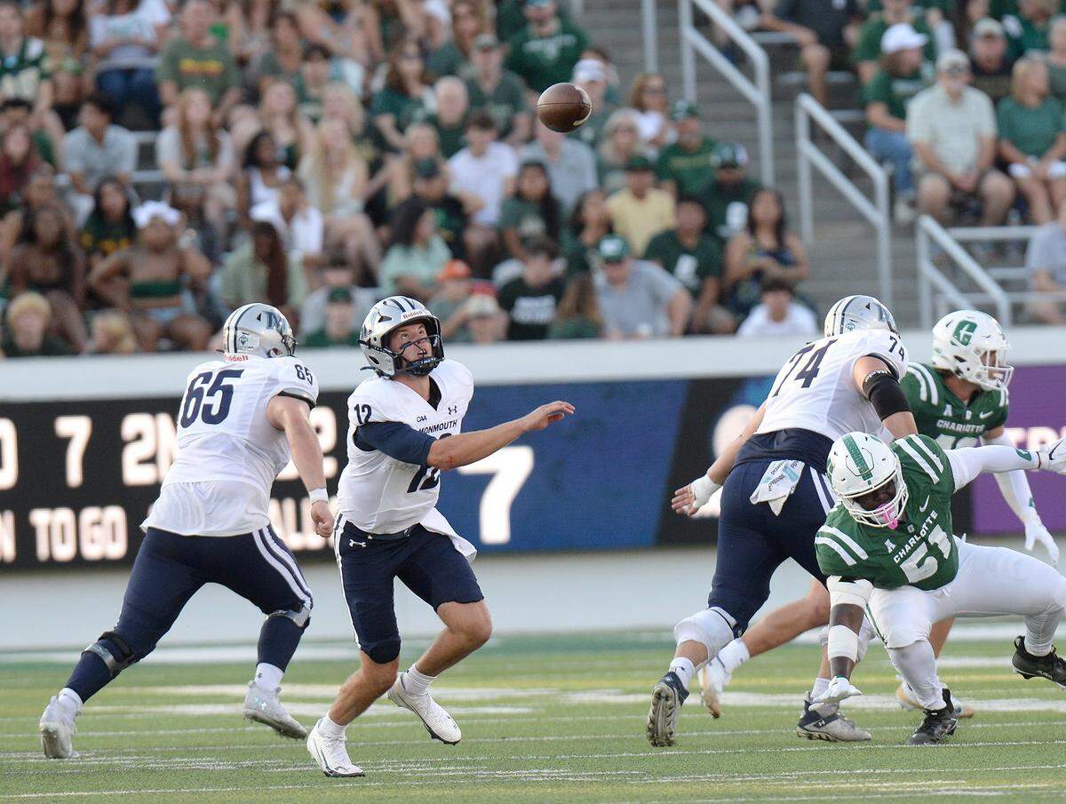 Monmouth quarterback Derek Robertson (12) watches an errant second-quarter snap sail over his head. Robertson recovered the ball.