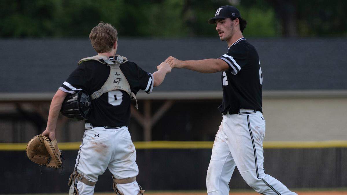 Hough high school pitcher Hampton Gilchrist fist bumps his catcher Andrew Schuldt on the way to the dugout after closing out the inning. The Huskies defeated the Vance Vipers 10-0 in 5 innings to finish the season 14-0 on June 11, 2021 at Hough High School.