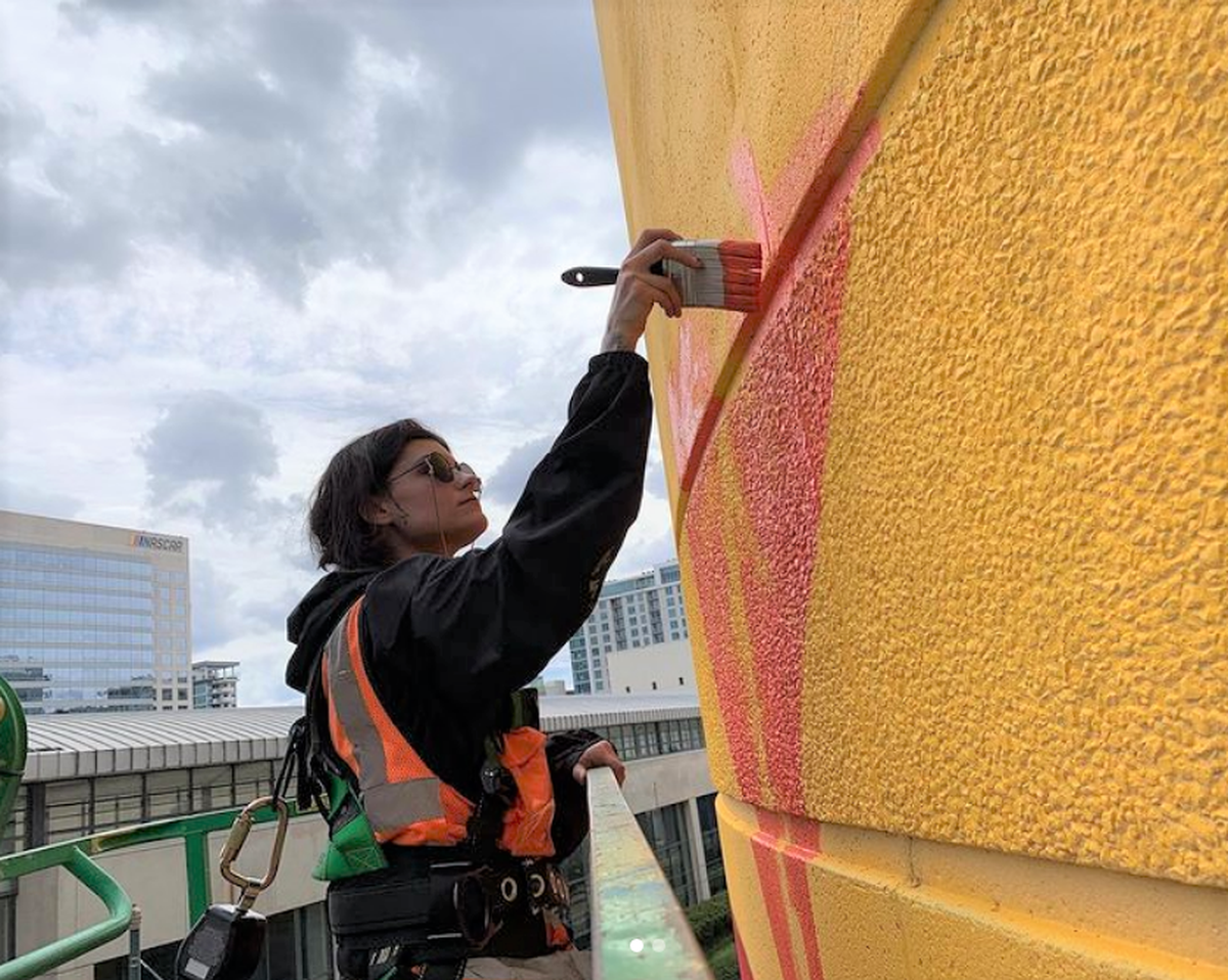 Sam Guzzie spent part of the spring working on her final mural. She collaborated with two other artists on the roughly 80-foot-tall piece in uptown Charlotte.