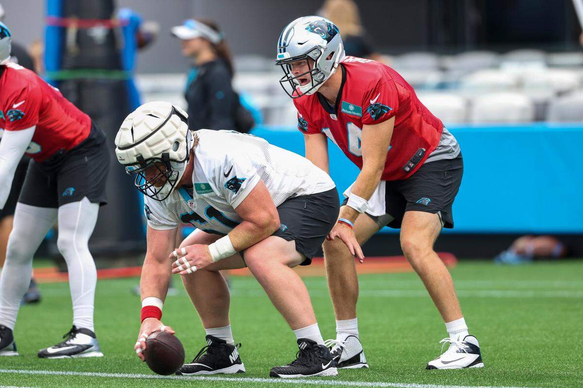 Carolina Panthers quarterback Sam Darnold, right, takes the snap from center Matt Paradis during a Fan Fest practice at the NFL football team’s training camp in Charlotte, N.C., Friday, Aug. 6, 2021. (AP Photo/Nell Redmond)