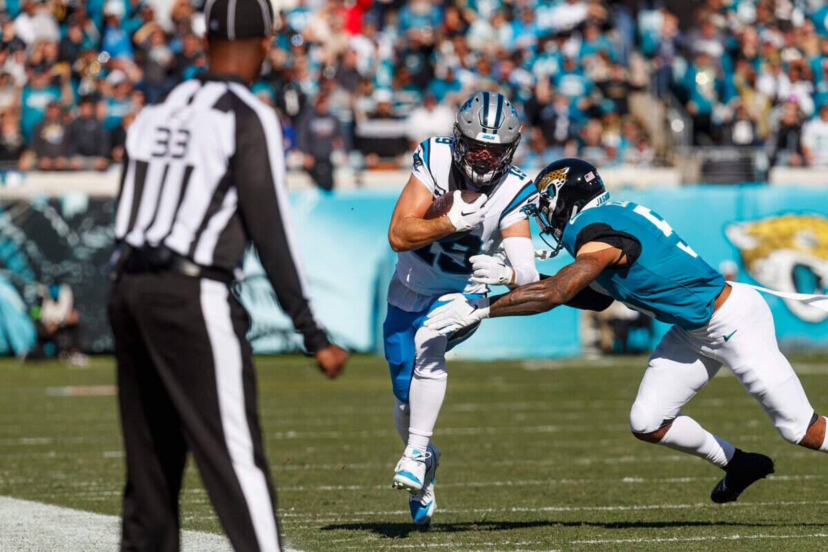 Jacksonville Jaguars safety Andre Cisco (5) tackles Carolina Panthers wide receiver Adam Thielen (19) during the first quarter at EverBank Stadium.