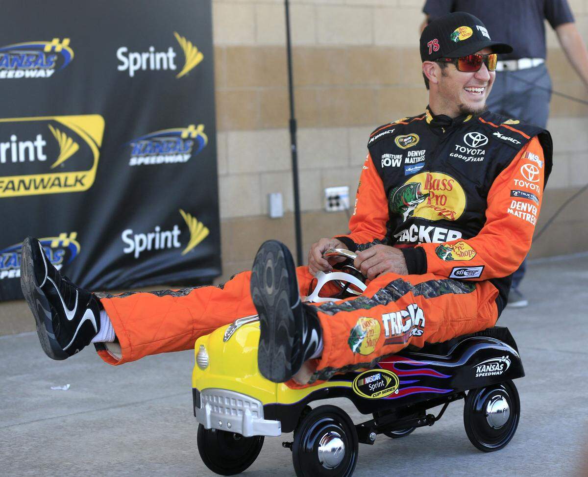 Martin Truex Jr. sits on the Kansas Speedway Pole Award after qualifying for the pole positions at the NASCAR Sprint Cup Series auto race at Kansas Speedway in Kansas City, Kan., Friday, May 6, 2016. (AP Photo/Orlin Wagner)