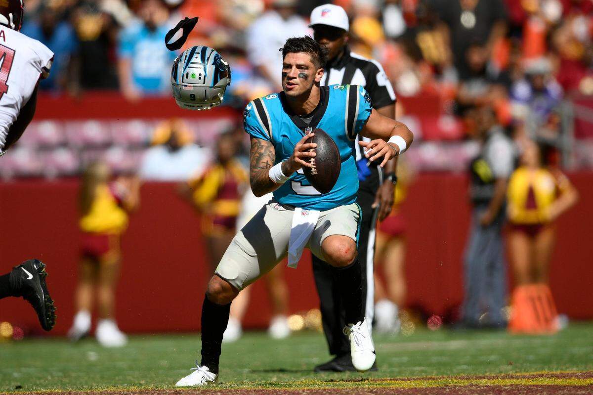 Carolina Panthers quarterback Matt Corral loses his helmet after it was pulled off by Washington Commanders defensive end Shaka Toney during the second half of a preseason NFL football game, Saturday, Aug. 13, 2022, in Landover, Md.