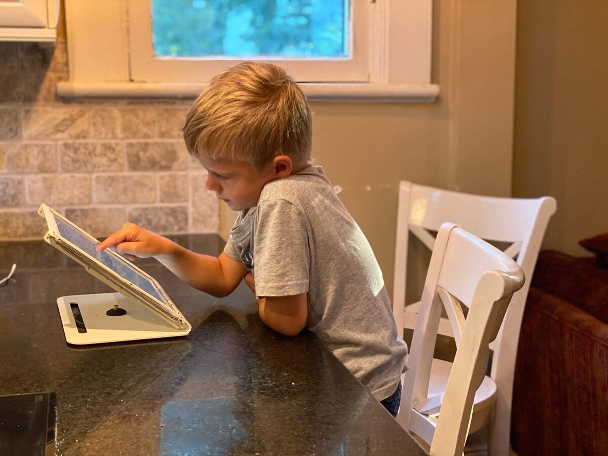 Isaac, a kindergartener, takes a MAP test at the kitchen counter. 