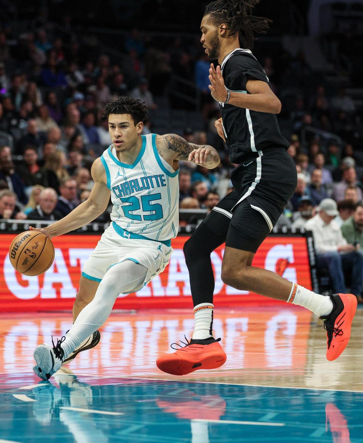 Hornets guard KJ Simpson, left, drives the ball around Nets guard Dariq Whitehead during the game at Spectrum Center in Charlotte, NC on Wednesday, January 29, 2025.